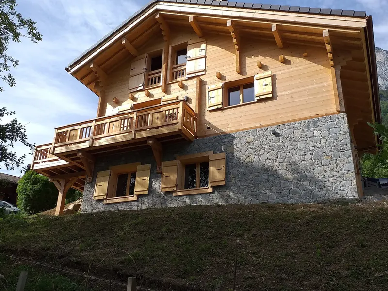 Chalet madrier en cours de montage sur socle maçonné