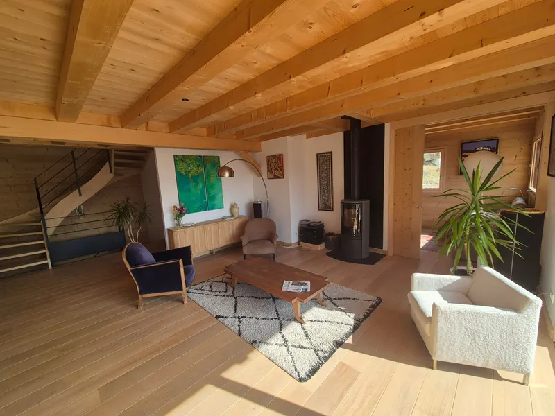 Pièce de vie lambrissée avec escalier bois