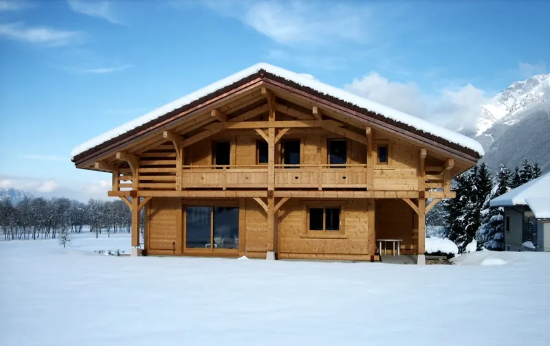 Chalet madrier sous la neige, rangs de madriers apparents